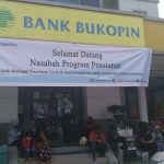 TELANTAR: nasabah bertahan di depan Bank Bukopin menunggu layanan.